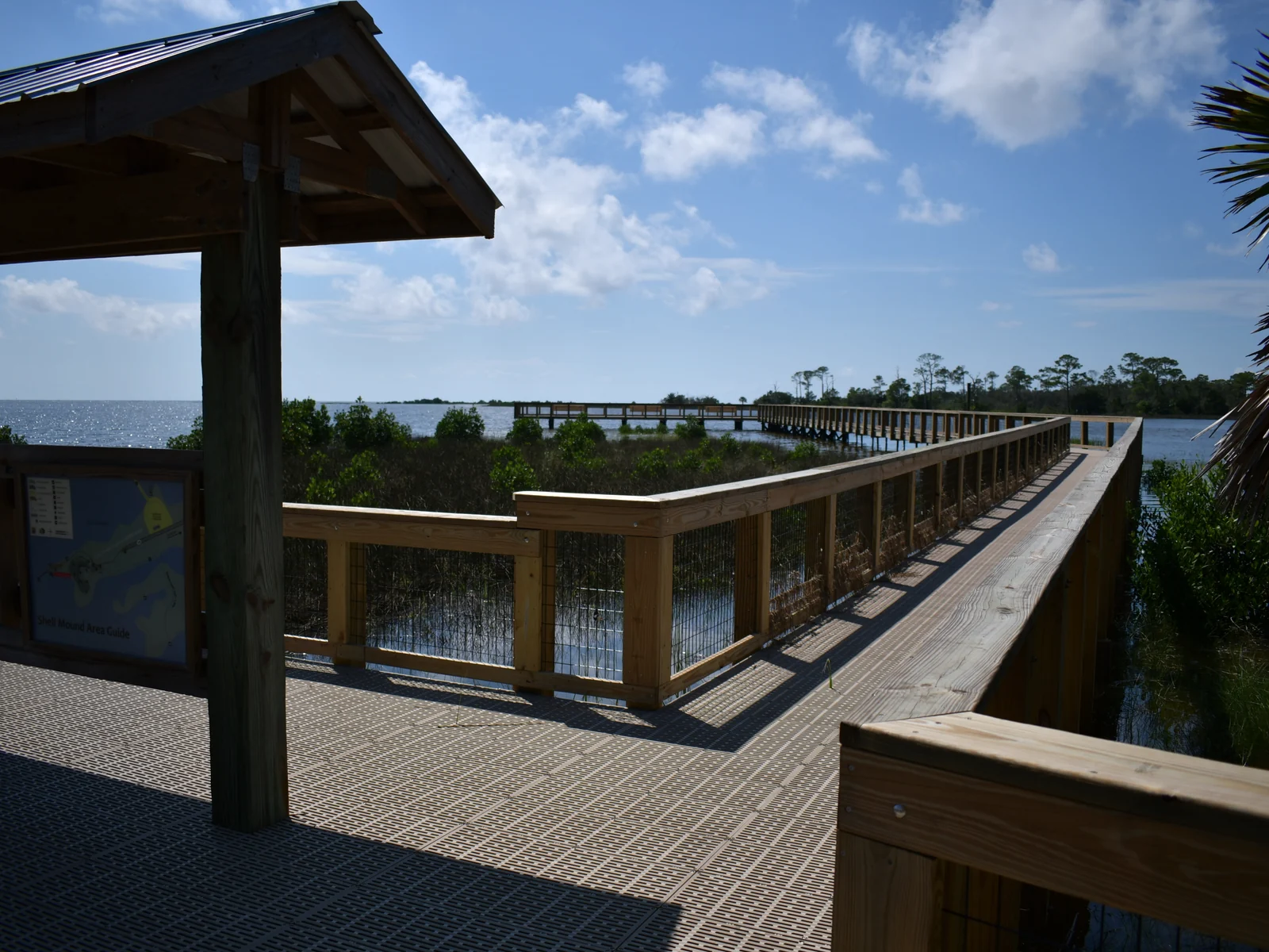 Public-domain Shell Mound pier with perforated deck panels, boardwalk and coastal water; environment reference